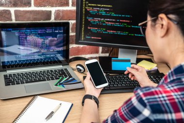 diğer elektronik ürünleri ile masa üzerinde bir kredi kartı ve smartphone kullanarak arkadan görünüm.
