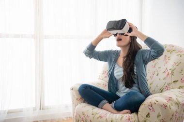 Onun Vr kafasına tutarak ve oturma odasında kullanırken heyecanlı duygu genç kadın.