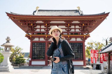 etrafında tarama ve bu geleneksel Japon tapınakta çekim için çalışıyor güzel Asya ziyaretçi.