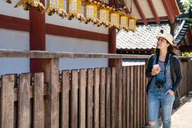 telefonunuzun ve çitler güzel Japon tapınak Osaka tarafından yürürken çekici Asyalı kadın.