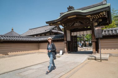 bir kadın ziyaretçi ziyaret etti ve geleneksel Japon mimarisinin giriş yürüme.