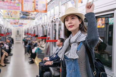 ayakta ve Osaka tren çekerken kolu tutan çekici genç kadın.