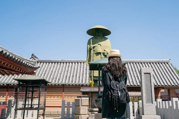 日本の有名な寺院の一つの像の前で立っているアジア女性訪問者の背面図 — ストック写真