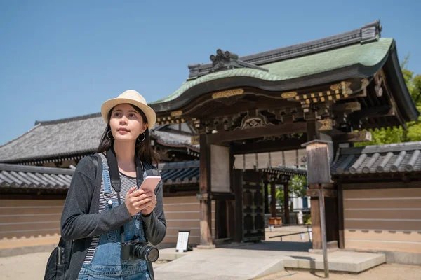 Όμορφη Γυναίκα Χρησιμοποιώντας Smartphone Ενώ Αξιοθέατα Ένα Παραδοσιακό Ιαπωνικό Ναό — Φωτογραφία Αρχείου