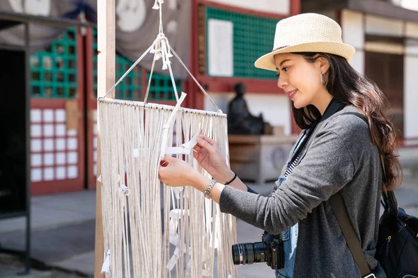 Pretty Asain Visitor Tying Japanese Fortune Paper Ropes Wishing Good — Stock Photo, Image