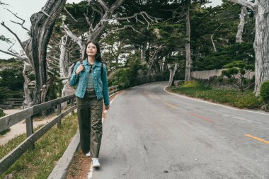 ağaçlar ve bitkiler sevinçle çevreleyen ile yol boyunca yürüyüş oldukça Genç Asyalı kız.