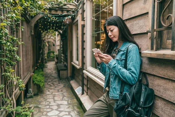 Krásná Žena Pomocí Chytrého Telefonu Naklonil Retro Uličce Rostlinami Okolí — Stock fotografie