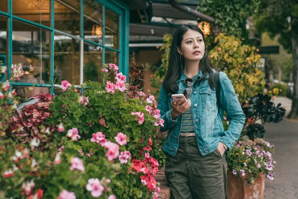 Onun Smartphone Tutarak Çiçekler Ile Çok Güzel Bir Önünde Duran — Stok fotoğraf
