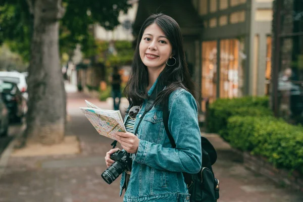 女人微笑着快乐地拍着相机 手里拿着导游图 漫步观光 — 图库照片