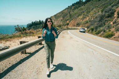 Dağlardaki sürüş bir uzun saat sonra yürüyüşe bir mola için yolda bir seyahat kadın.