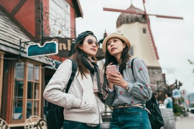 etrafı kontrol için sokak ve bir akıllı telefon tutarak bir duran iki iyi arkadaş.