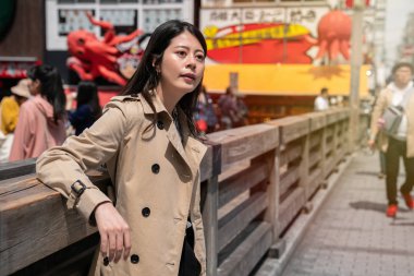 Zarif Bayan yaya köprüsü üzerinde ayakta ve alışveriş sonra dinlenme