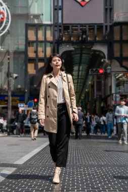 Sabah işe yarayacak sokakta yürürken Japon hanım. casual elbise giyiyor.