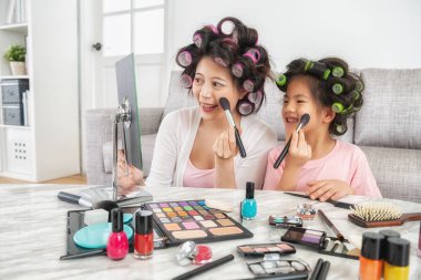 zarif genç anne sevimli küçük kızını makyaj yapmayı öğretiyor