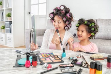 zarif genç annesini makyaj yaparken sevimli küçük kızını makyaj öğreniyor