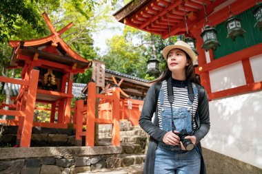 kendinden emin bir kadın turist tapınağın yürüyüş ve onun elinde kamerayla harika binasında arıyorum