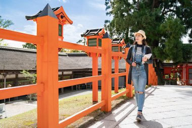 zarif bir kadın turist tapınakta yürüyüş ve onun rehber kitap tutan bir tam uzunlukta fotoğraf