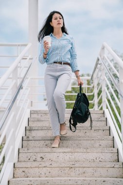 merdivenlerden aşağı yürüme ve onun sırt çantası taşıyan kadın bir gezgin bir tam uzunlukta fotoğraf