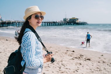 bir çok kadın fotoğrafçı güneş gözlüğü takıyor ve sahilde duran