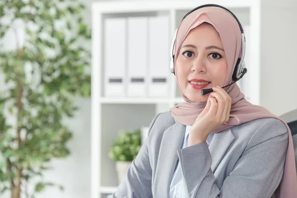 穆斯林女特工戴着耳机 用话筒回答客户的问题 女实业家在办公室西装坐在工作场所 — 图库照片