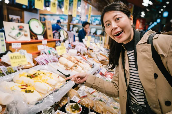 Красивая Женщина Турист Лицом Камере Улыбается Указывает Японскую Уличную Еду — стоковое фото
