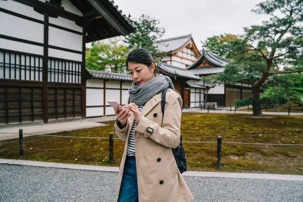 Κομψή Γυναίκα Στέκεται Μπροστά Από Ναό Χρησιμοποιώντας Smartphone Για Αναζητήσετε — Φωτογραφία Αρχείου