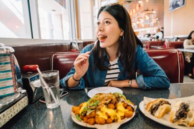 güzel seyahat deneyimi Amerikan kültürü. Amerikan yemek yeme ve Amerikan restoranda oturan genç kız. lokantada La kavramı.