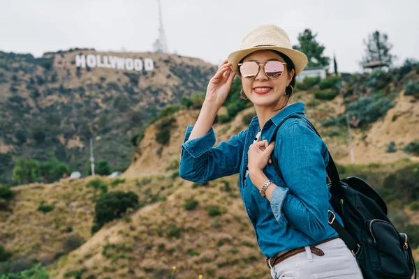 可爱的女士戴着太阳镜和草帽 脸上带着笑容欢快地微笑 优雅的女人享受蓝天的美丽 女性旅行者在美国的春季假期 — 图库照片