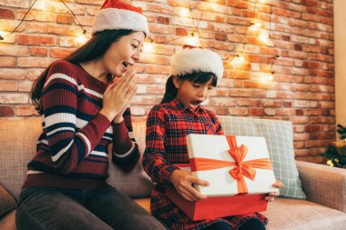 şirin çocuk annesiyle Xmas hediye kutusu açılıyor. küçük kız çocuk alışveriş online anneden hediyem tarafından şaşırttı. Noel tatil Aile kavramı.