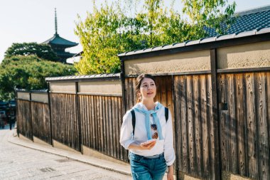 kadın turist etrafına duvar Japon pagoda için yürüyüş. Genç kız backpacker bağımsız gezisi Japonya'da yaz tatili. huzurlu kasaba Kyoto sokakta.