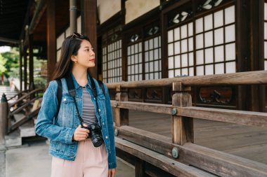 Kamera tutarak ve ahşap binaya arıyorsunuz Asya Bayan. kadın fotoğrafçı tapınakta yürüme. Asya seyahat tatil Kyoto Japonya'da.