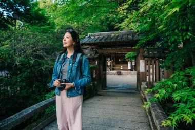 güzel turistik tapınağın önünde ayakta ve orman resim çekmek hazır. Neşeli backpacker seyahat eğlenceli yaz Japonya. Bayan fotoğrafçı Tapınağı ziyaret.