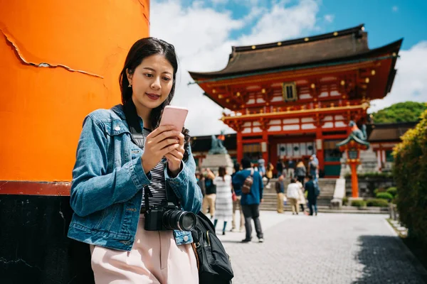 女性観光客の携帯電話を使用して 彼女の家族に連絡して神殿の外それらを待っています 女寺旅行休暇に携帯電話を使用して 日本でツアー旅行 — ストック写真