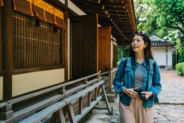 Hermosa Fotógrafa Sosteniendo Cámara Mirando Alrededor Del Edificio Tradicional Japonés — Foto de Stock