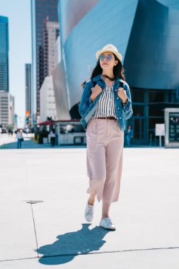 tam uzunlukta fotoğraf güzel Gezgin içinde belgili tanımlık geçmiş ünlü konser salonu ile yürüme. Genç kız turist Güneşte ayakta dışında. Popüler Tur Los Angeles'ta spot.