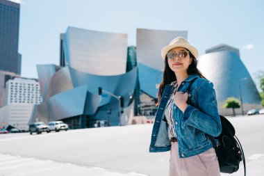 ünlü konser salonu önünde duran güzel kadın gezgin. Genç Çince los Angeles'ta bulunan meşhur mekanlar ziyaret çanta ile öğrenci değişimi. Yalnız Amerika'da seyahat.