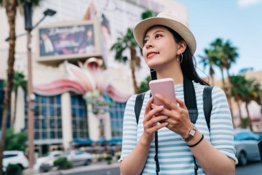 Las Vegas'ta sokakta yürüme ve casino için yol bulmak gezgin. Genç Bayan hobi doğru yolda almak için çevrimiçi harita app cep telefonu kullanarak bir kumarbaz olduğunu. vegas'ın ünlü gezi nokta.