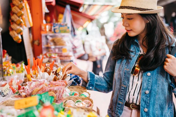 エレガントな女性の伝統的な市場でお菓子キャンディー ベンダーを選択します 旅行者は メキシコの屋外ベンダーの名物を見てします アメリカのライフ スタイル旅行します — ストック写真