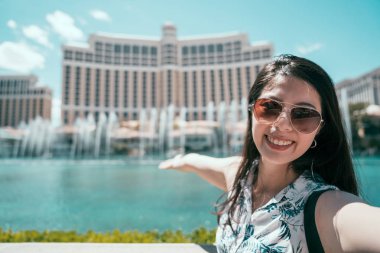Selfie alarak güneş gözlüklü Asyalı kadın las Vegas otel Çeşme önünde fotoğraf. Amerika'da yaz tatil kız zevk seyahat. mutlu gülümseyen turist kendi kendine portre fotoğraf çekme.
