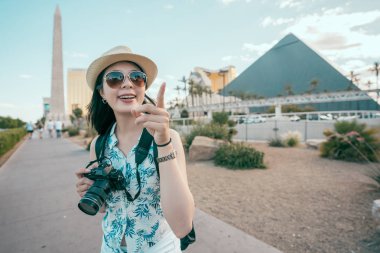mavi gökyüzü duran piramitler Las vegas'ın önünde işaret turist fotoğrafçı. Şapka ve güneş gözlüğü gülümseyen Asyalı kadın. ABD'de yaz tatil seyahat.