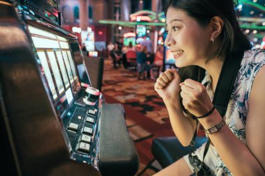 Asyalı kadın para harcama slot makineleri oynamak casino kumar. Makine spin için bağımlısı kumarbaz. tatil sırasında las vegas oyun oynarken eğleniyor kız.