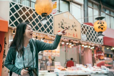 satıcı kuromon piyasada işaret turist objektif adam yola jp. Genç Bayan Japonya'nın geleneksel sokakta mağaza önünde heyecanlı. güzel kadın tatil yaşam tarzı.