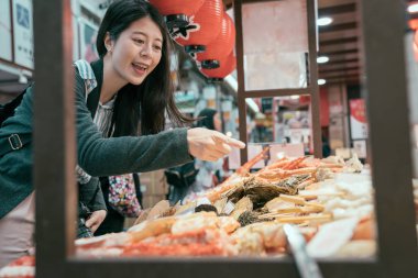 Japonya seyahat mobil mutfak tarihinde deniz ürünleri gösteren Bayan. Kız turist deneyim Japon kültürü. Genç gezgin hungrily sokak gıda satın.