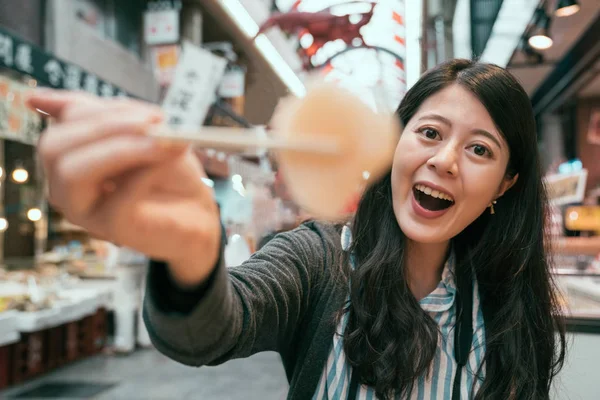 Smuk Turist Viser Sashimi Til Kameraet Med Spisepinde Fokusere Foto - Stock-foto