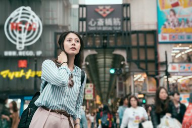 Genç gezgin shinsaibashi önünde duruyor. meşgul sokak kalabalığın içinde Japonya. güneşli günde Japon kentsel yaşam tarzı. insanlar kentsel sokakta yürüyor