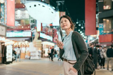 Genç Bayan backpacker tsutenkaku sokak temming tutuyoruz. Balık balon City Osaka koyu mavi gökyüzünde asılı. kadın kentsel gece yaşam tarzı.