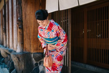 Japon bayan güzel kimono ile evinin önünde eğilerek. jp geleneksel bir yaşam tarzı. renkli kimono giyim yaz aylarında çekici kadın.