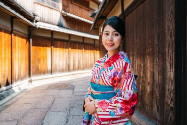 Çiçek desen eski caddenin Kyoto'da kimono ayakta bu güzel hanımla. Genç gezgin Ishibe sokakta Japon kültürünün keyfini çıkarın. Japonya'da güneşli günde seyahat.