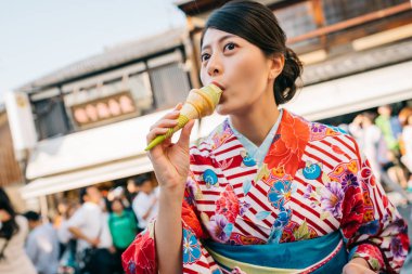 güzel Japon Bayan lezzetli matcha dondurma ayakta Japon sokakta yeme. Tatlı kavramı yeme çiçek kimono Japon kızla. Japon yaz yaşam tarzı.