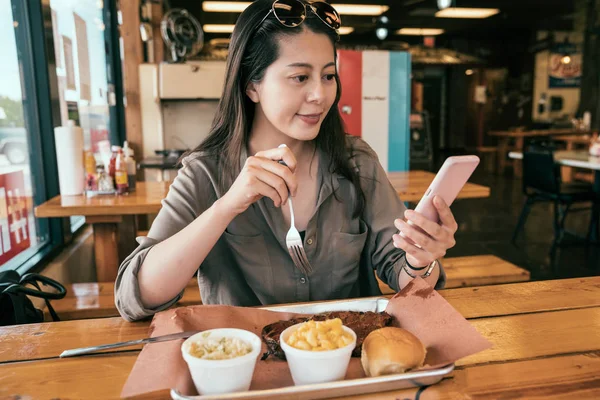 亚洲妇女使用手机和上传的照片美味的午餐在线共享应用程序 年轻的女孩坐在美国吃饭 优雅的女士看电影在下午茶时间 — 图库照片
